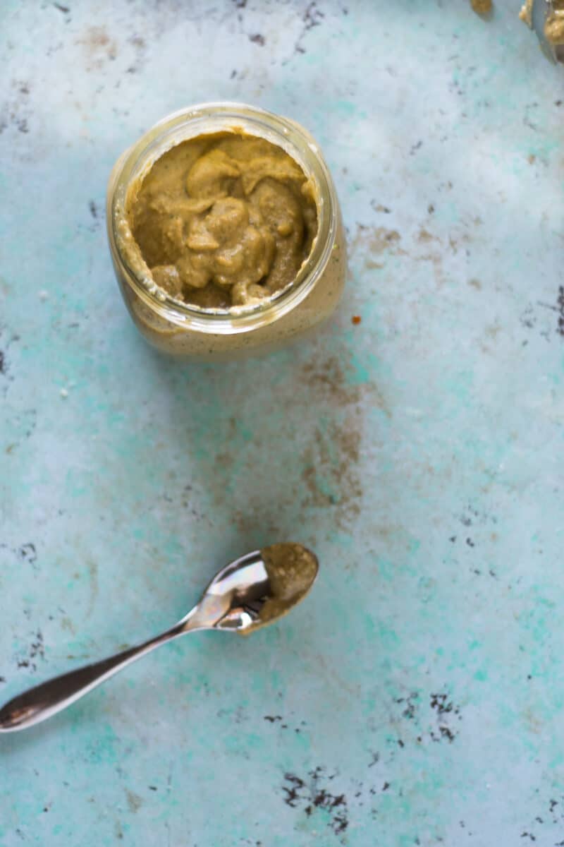 一罐大蒜腰果酱旁边放着一把勺子