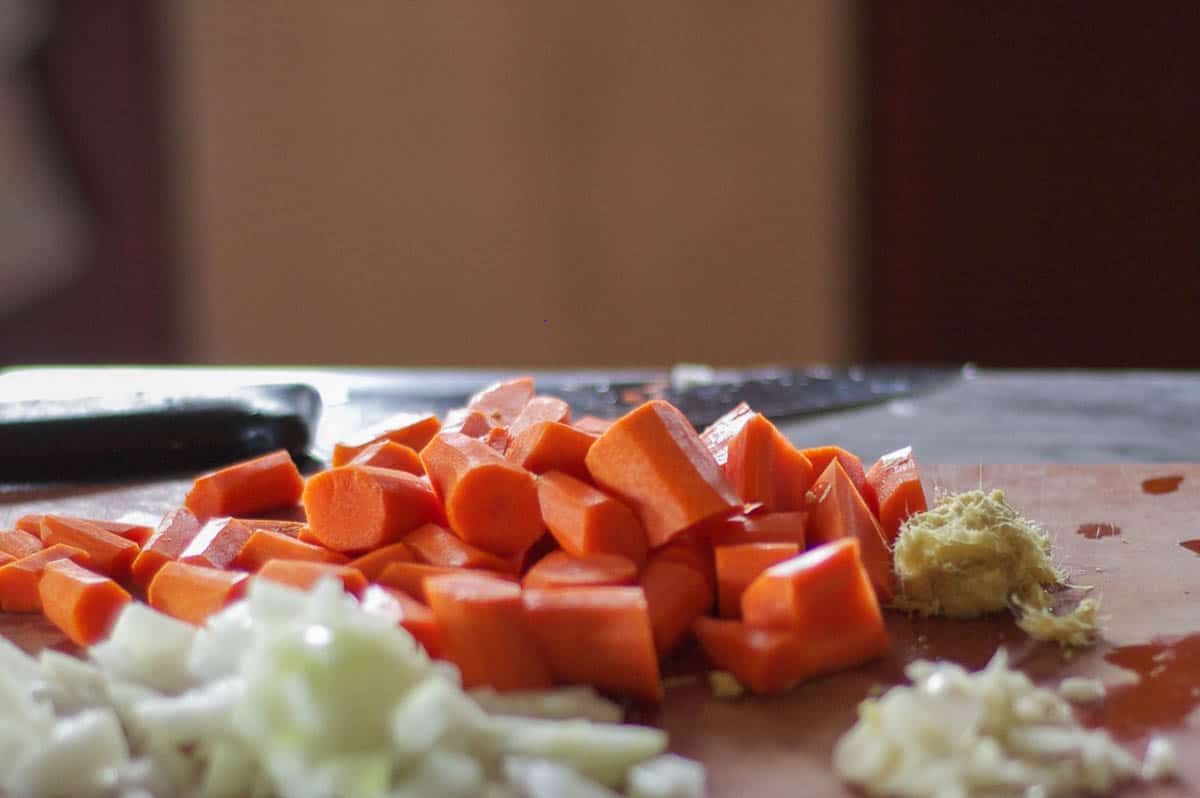 切碎的胡萝卜，洋葱和姜放在砧板上