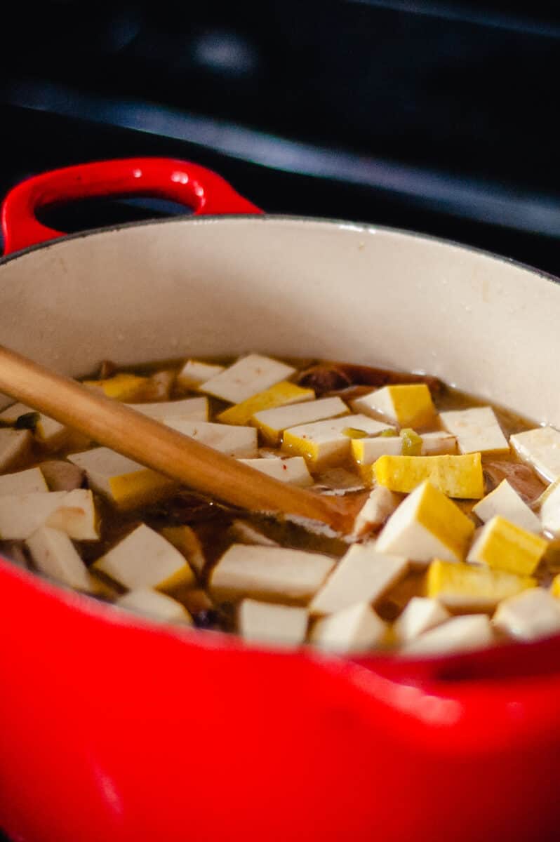 在红色荷兰烤箱中的热和酸汤的豆腐