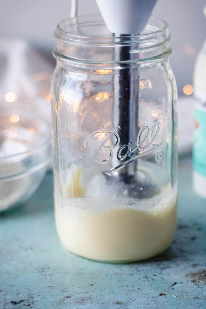 浸入式搅拌机将蛋奶酒放入玻璃瓶中搅拌