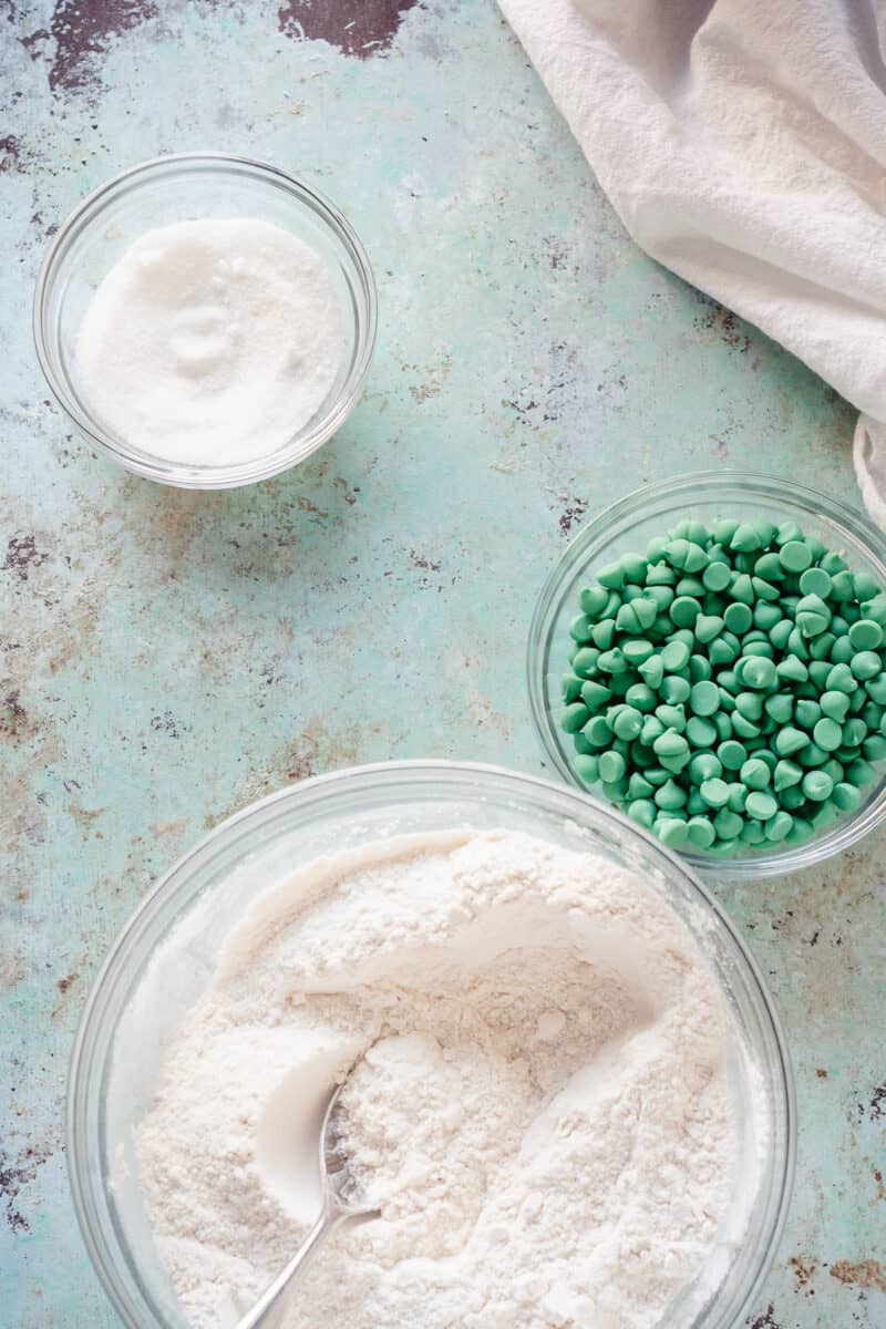 面粉混合物，绿色薄荷芯片和糖在玻璃混合碗中