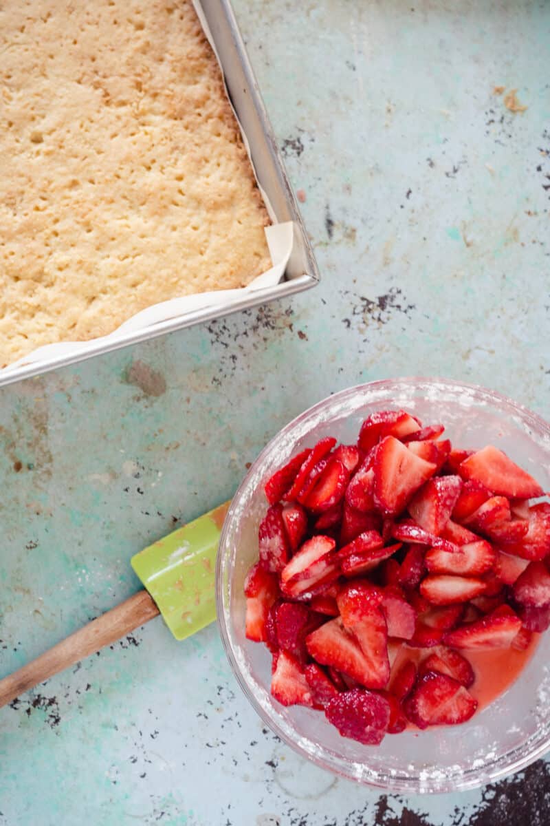 平底锅里烤脆皮，碗里放草莓片，加糖