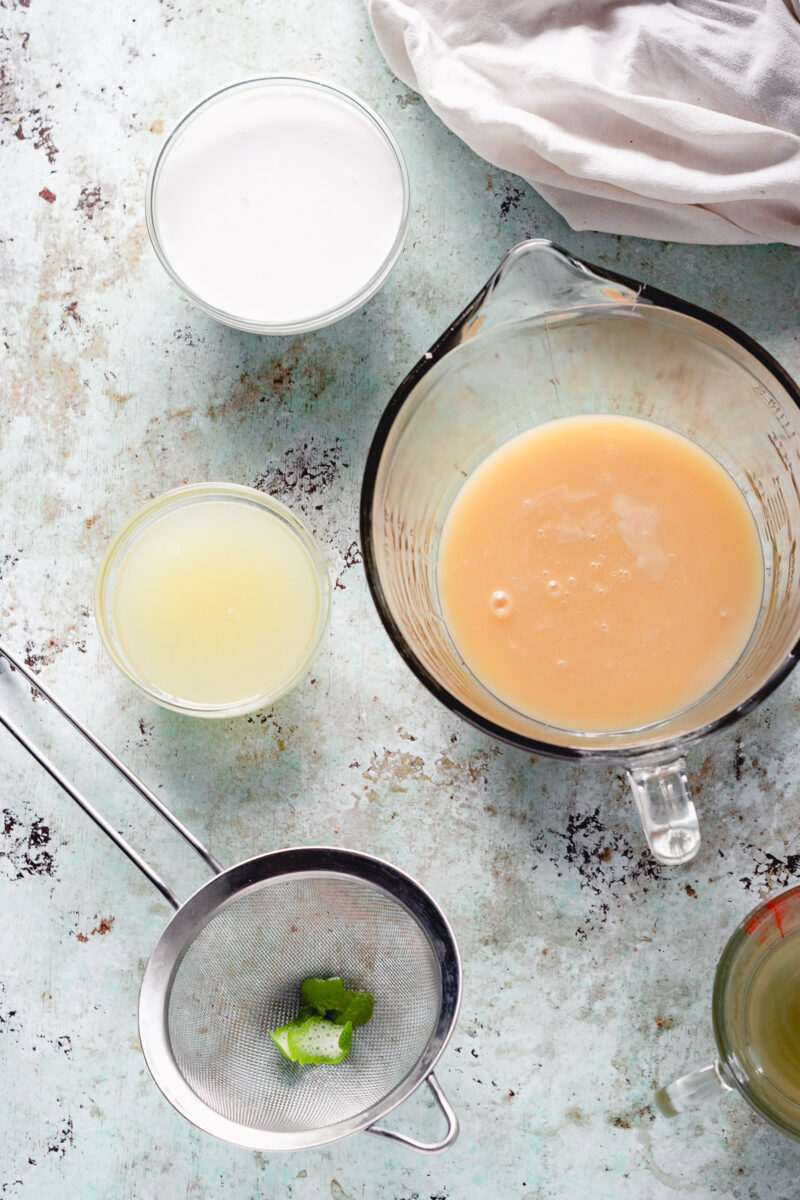椰奶在一个碗里，甜蜜的椰子牛奶在一个碗里，在一个碗里的石灰汁用石灰zest在过滤器中