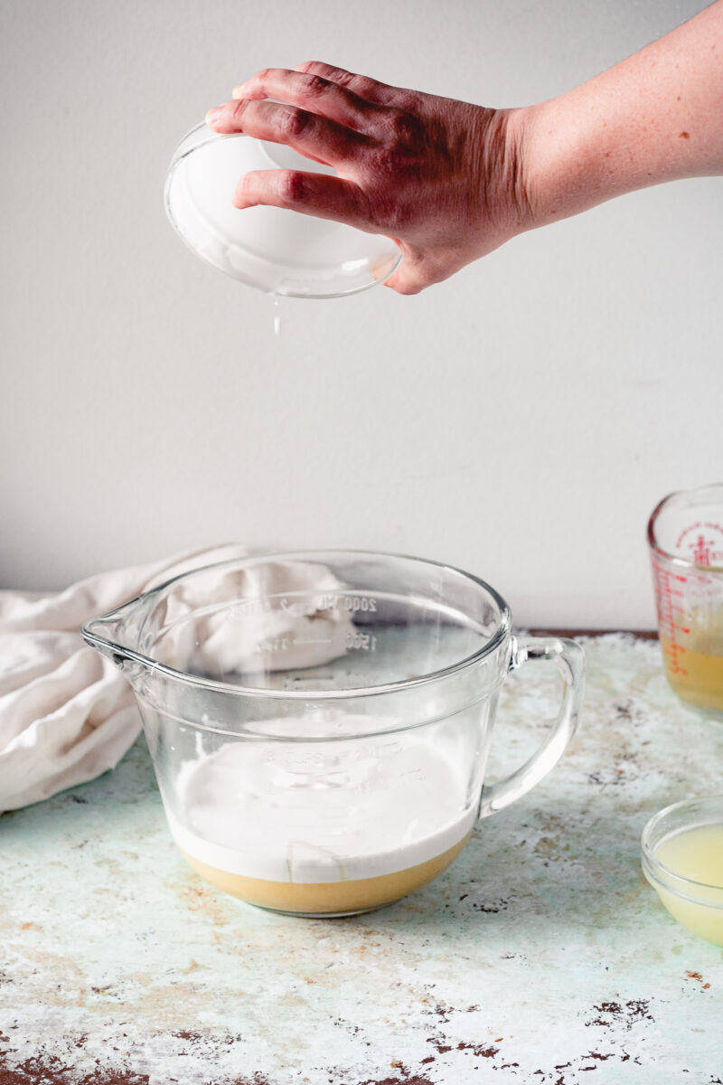 用手将椰奶和甜炼乳倒入搅拌碗中