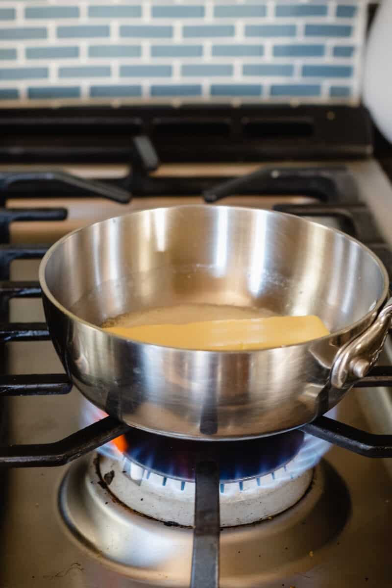 在煤气炉上的平底锅中熔化的一根黄油棒