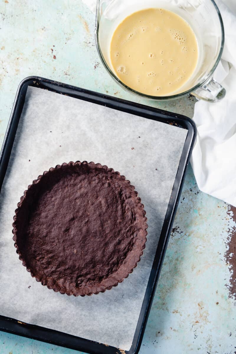 巧克力脆饼馅饼外壳在烘烤板上与填装旁边